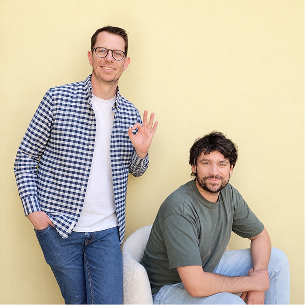 Photo présentation des frères chapron : Maxime debout à gauche faisant le signe "parfait" avec sa main gauche et Kévin assis à droite